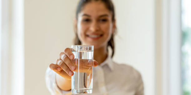 Young girl holding glass of water